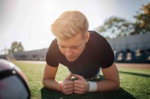 Young athlete doing planks exercise