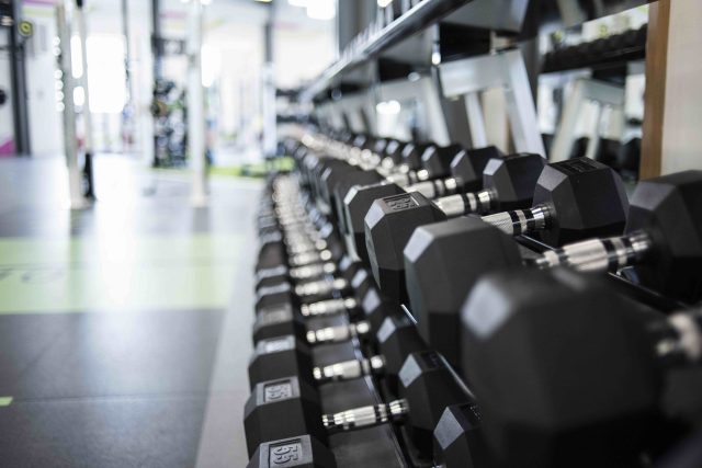 Closeup view of a rack of black dumbbells in a gym