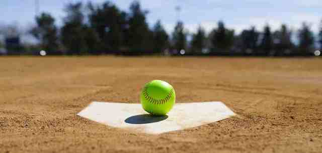 yellow baseball resting on home plate