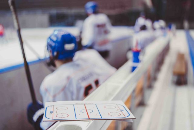 hockey players sit on the bench in the stadium