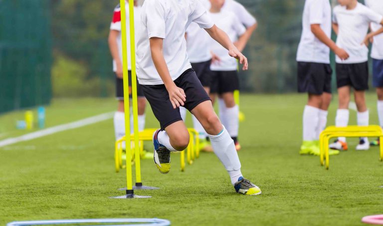 soccer players practicing speed and agility on field