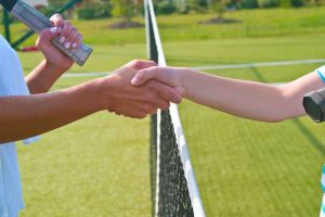 Tennis players shake hands before and after the tennis match.