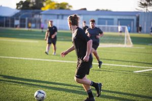 male athletes playing soccer outside