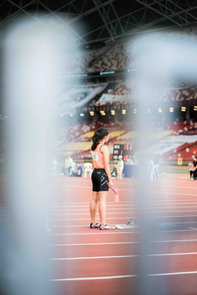 female track athlete holding baton