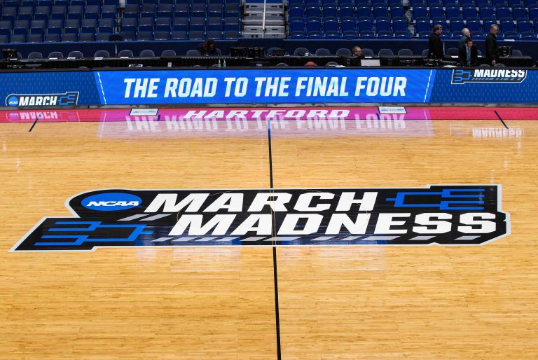 March Madness logo written on basketball floor
