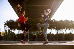 two young women doing gymnastic exercises outdoors