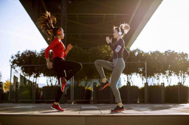 two young women doing gymnastic exercises outdoors
