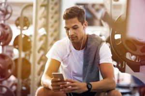 man using mobile phone in gym