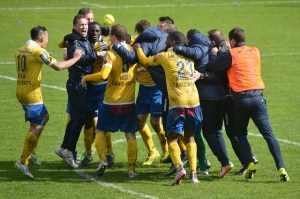 men's soccer team hugging happy on field