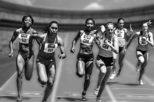 Black and white photo from in front of women racing on a track.