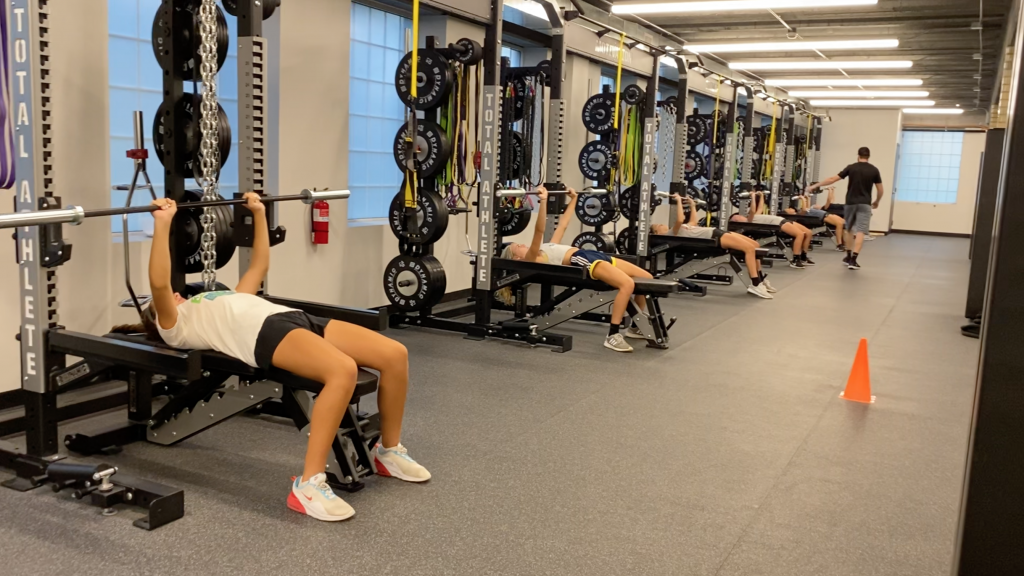 Athletes weight training in indoor sports performance center