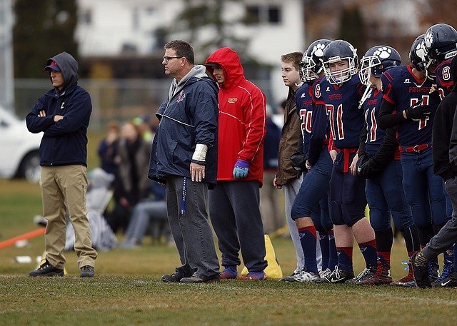 football team standing on the sideline