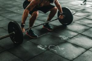 person squatting down, about to lift heavy weights