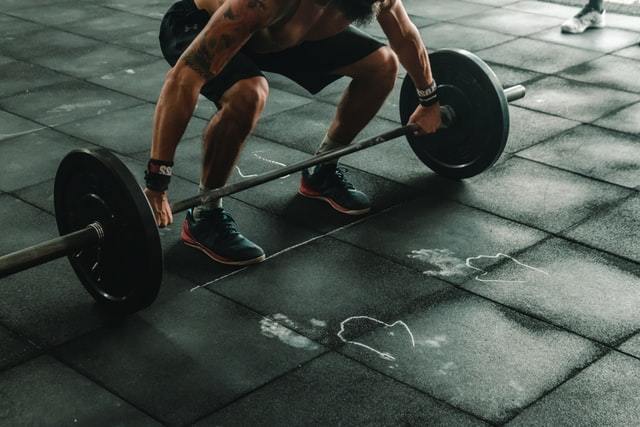 person squatting down, about to lift heavy weights