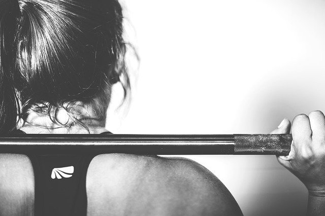 back of girl with a bar on her shoulders in black and white
