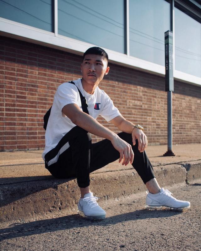 man sitting on street curb