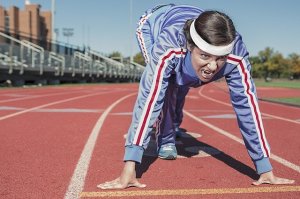 facing a woman in a starting position on a track with a fierce face