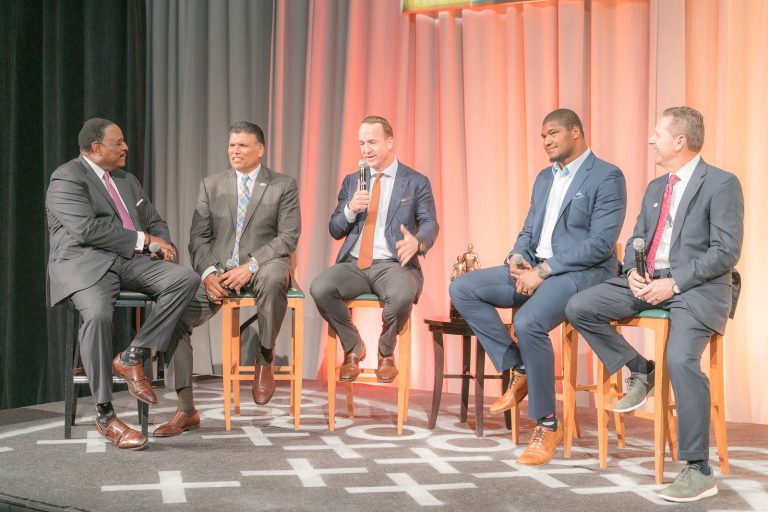 Five NFL personalities on chairs sharing during the Super Bowl Breakfast