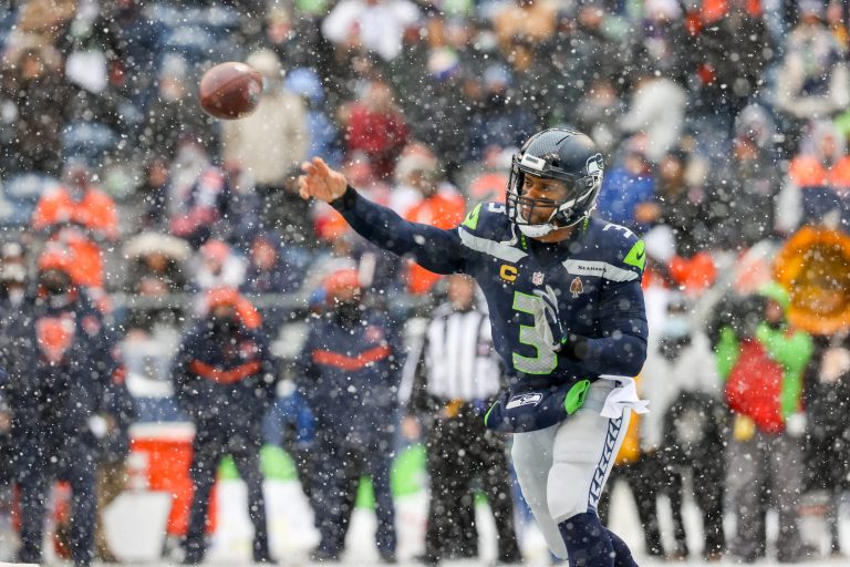Russell Wilson throwing a pass in the snow