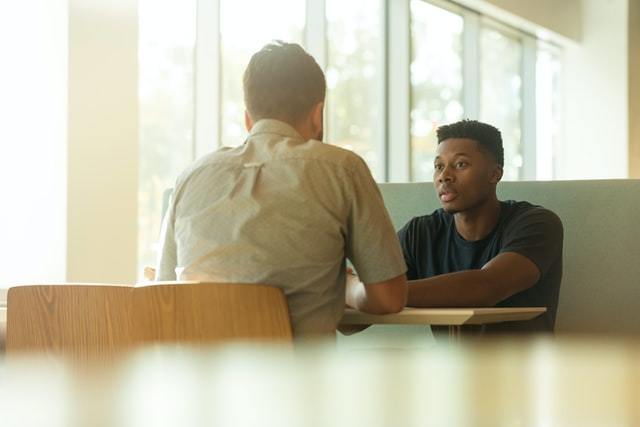 Two men sitting at a table facing each other