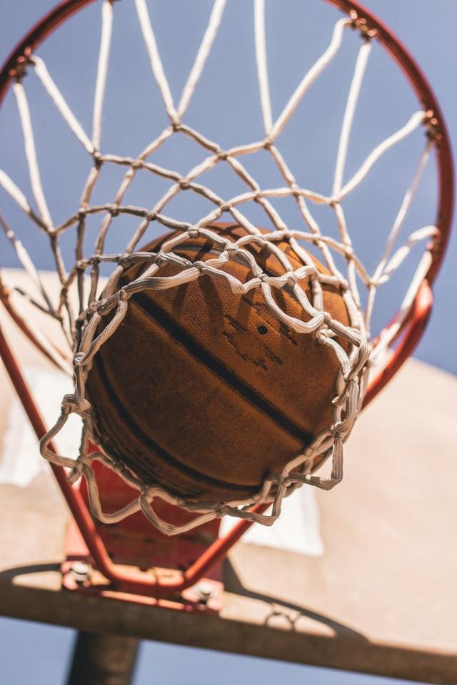 Basketball coming through the net as seen from below