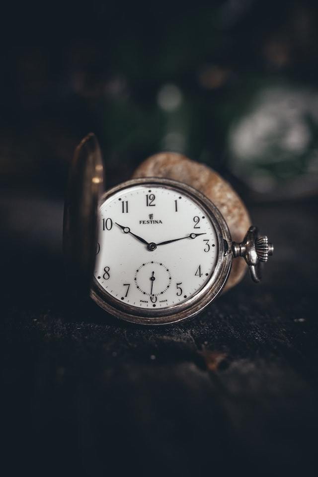 pocket watch showing the time of 10:12.