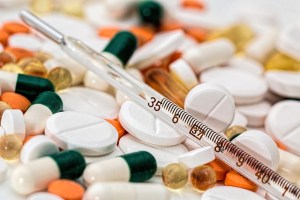 a thermometer laying across a variety of pills