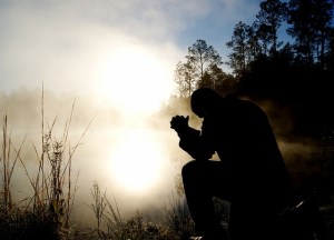 silhouette of person praying outdoors