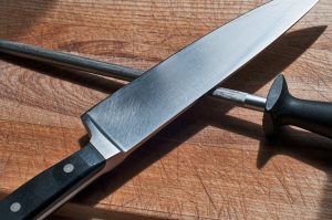 knife and sharpening tool on a cutting board