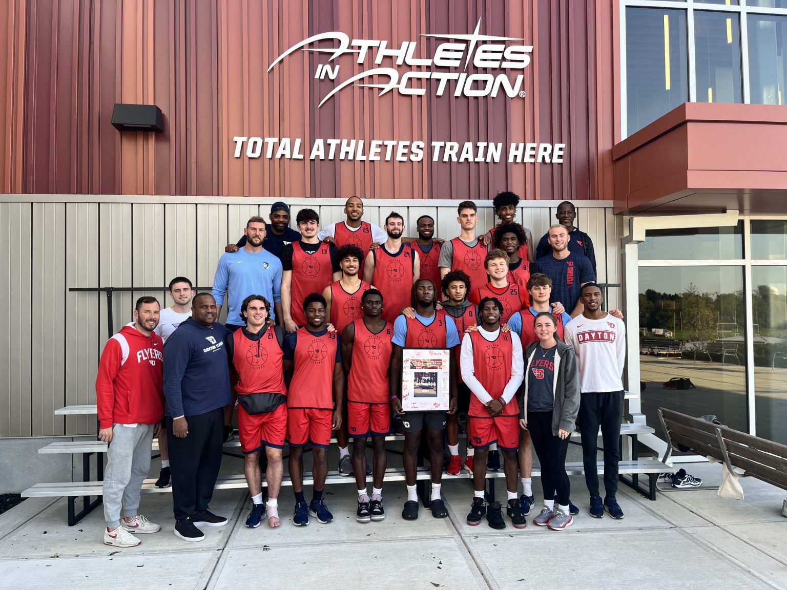 College team posing outside the Athletes in Action Fieldhouse