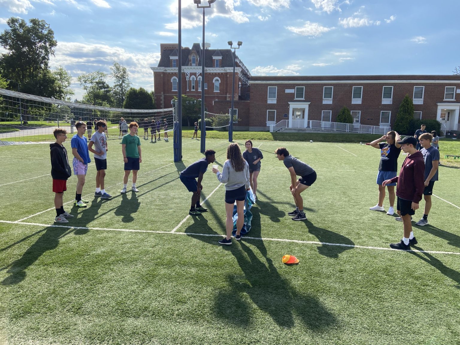 Team working together in an outdoor team-building activity on a turf field