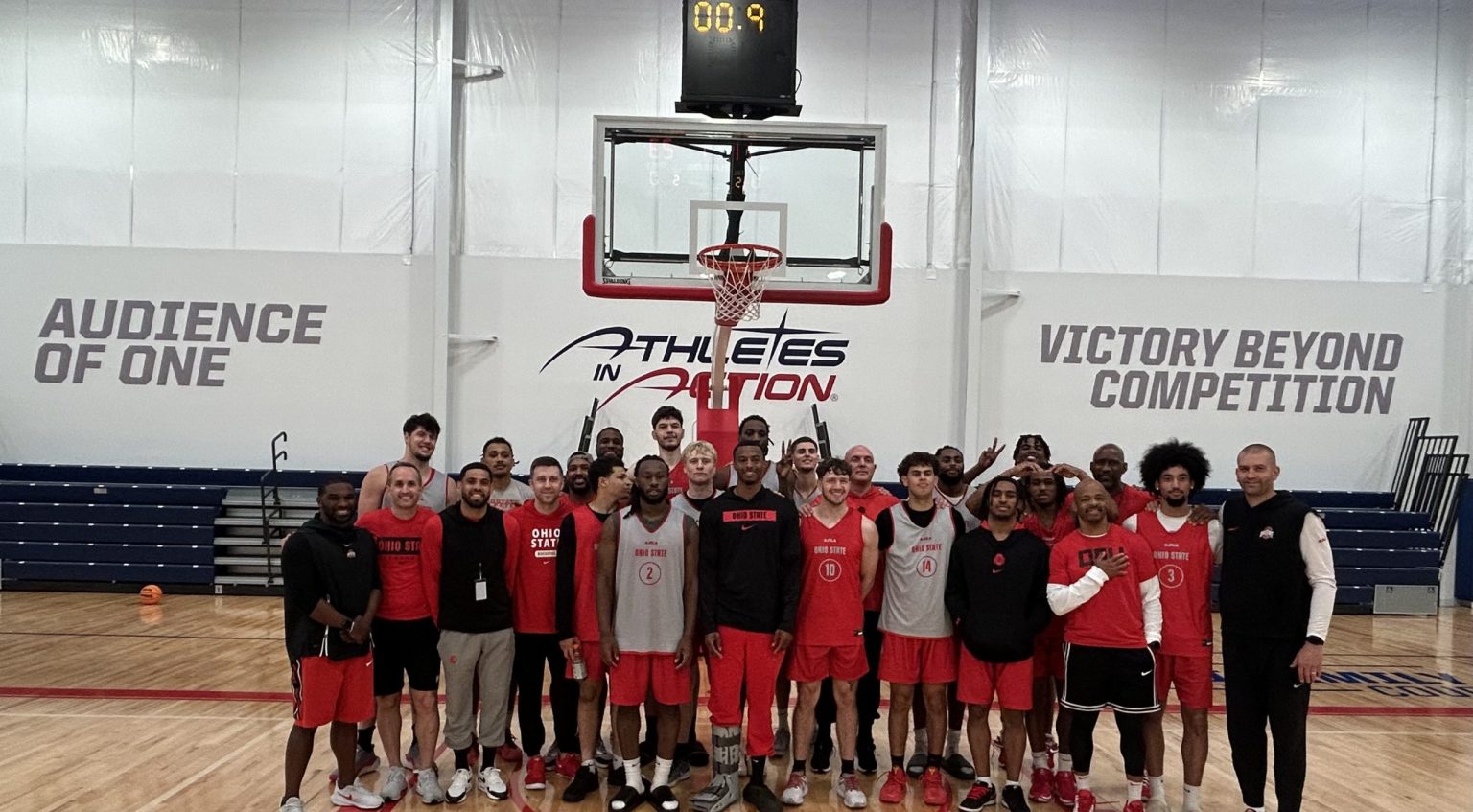 College basketball team celebrating together on the Fieldhouse court