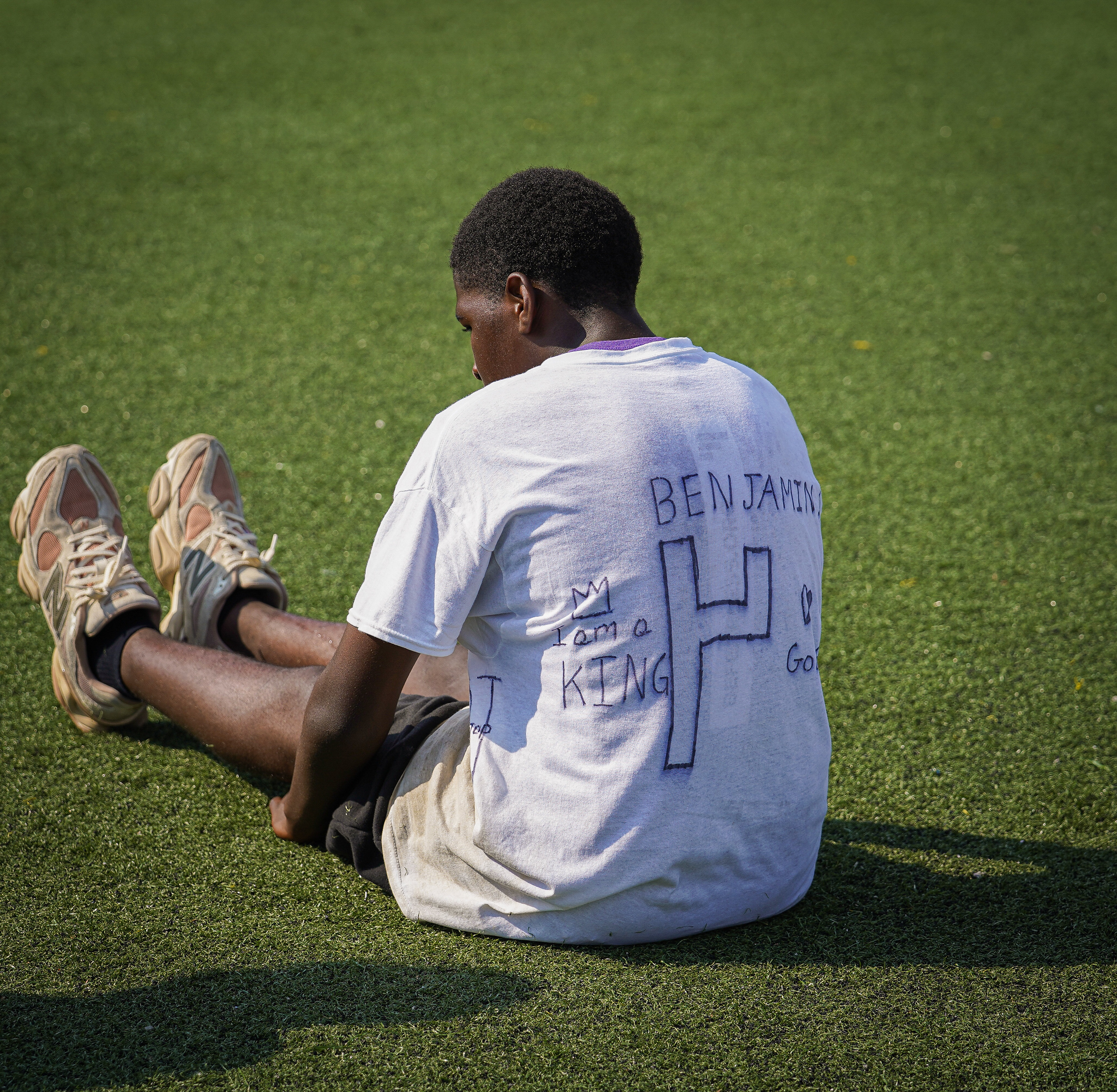 An athlete sitting alone on the turf at AIA Jam Camp