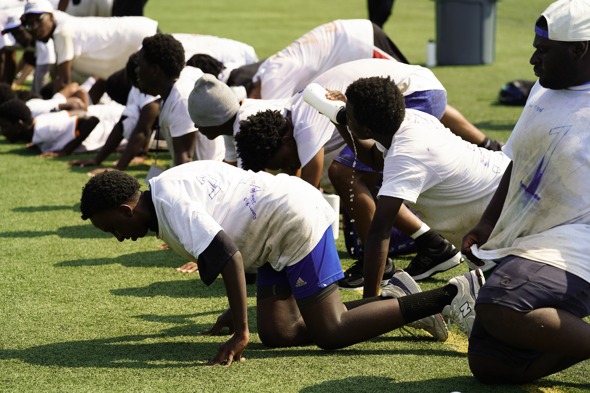 High school athletes doing a drill together on the turf at AIA Jam Camp