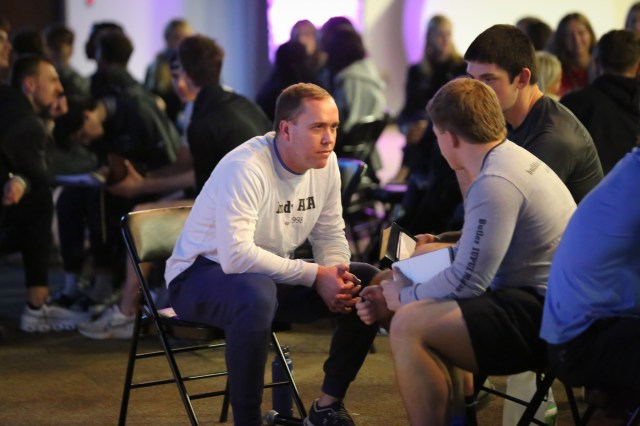 AIA staff member talking one on one with a college athlete at a retreat