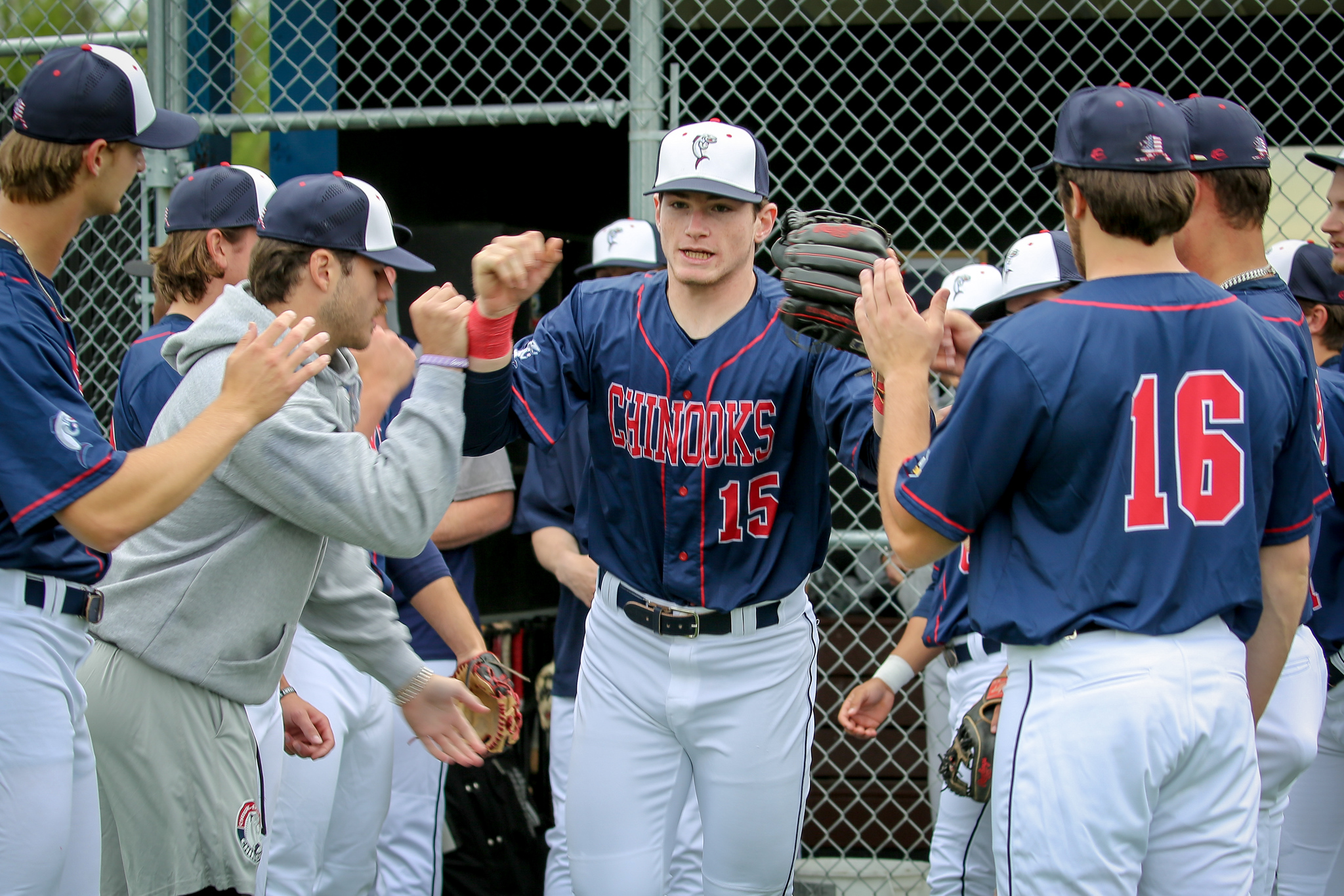 Chugiak-Eagle River Chinooks players high-fiving outside the dugout