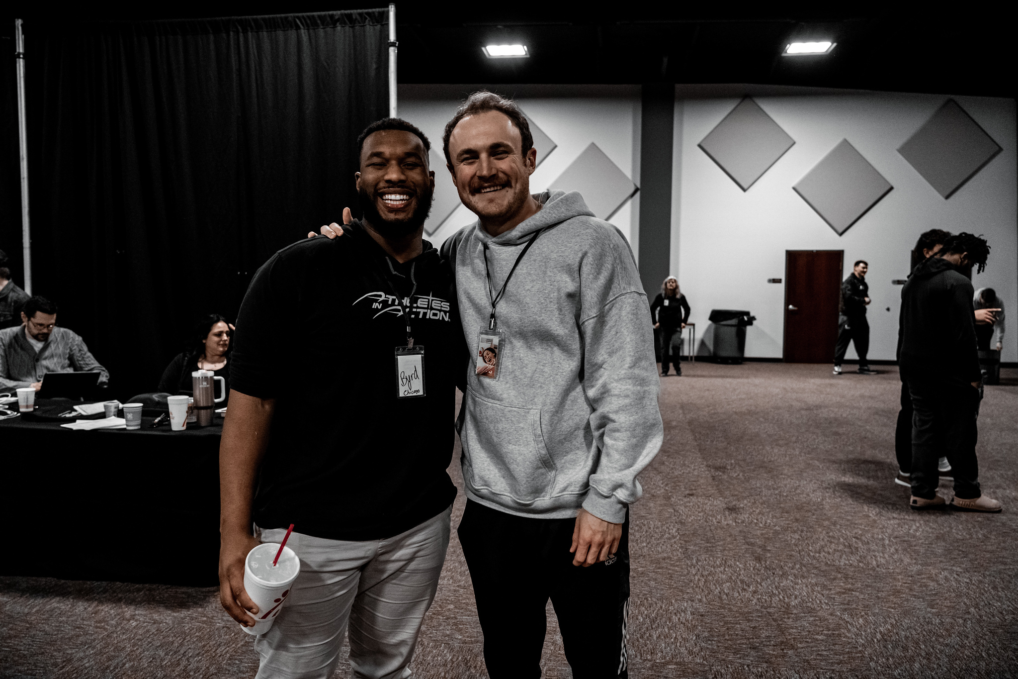 An AIA staff mentor and a college athlete smiling together at a winter retreat