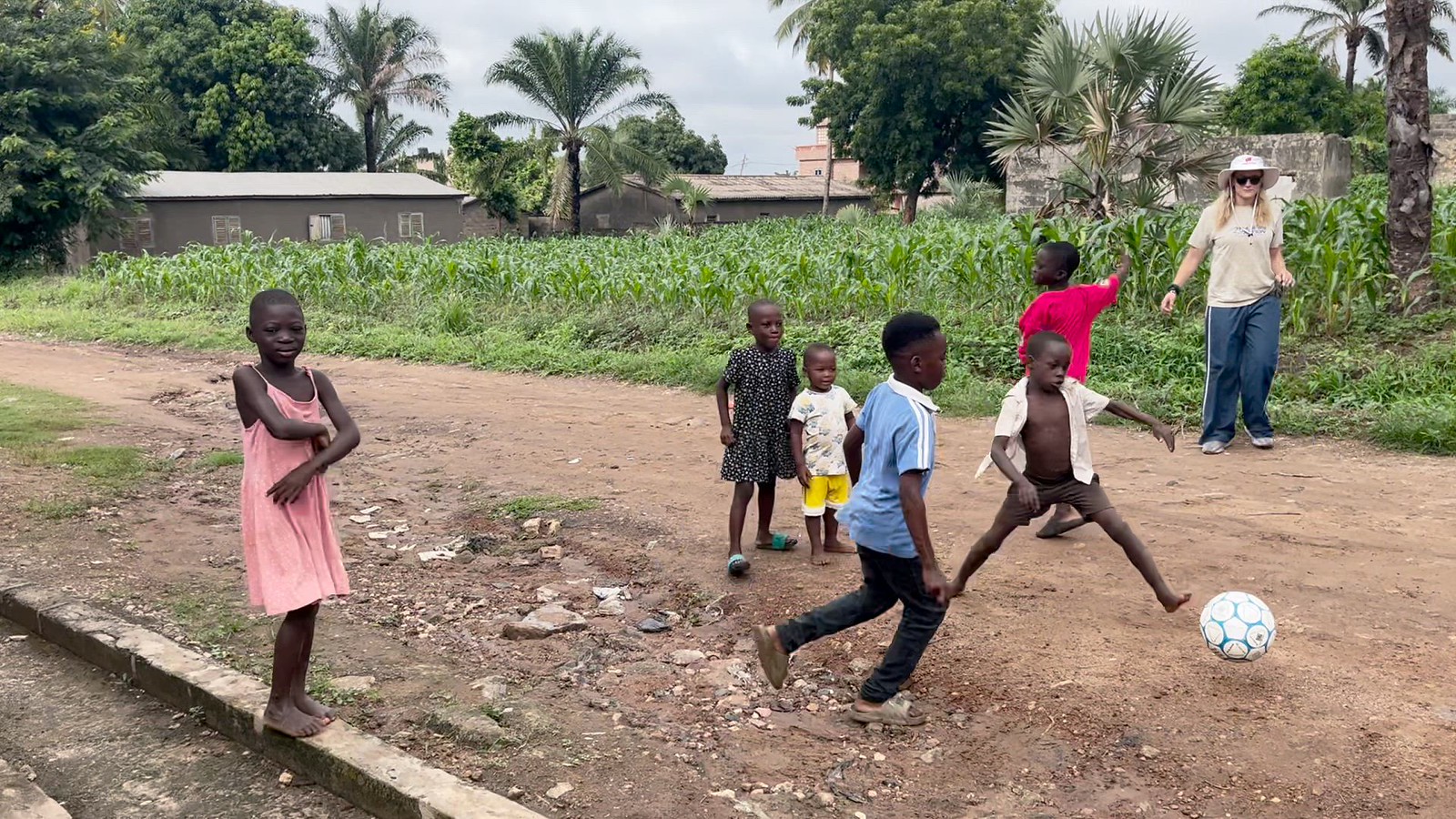 Local kids playing soccer with AIA athletes in Togo