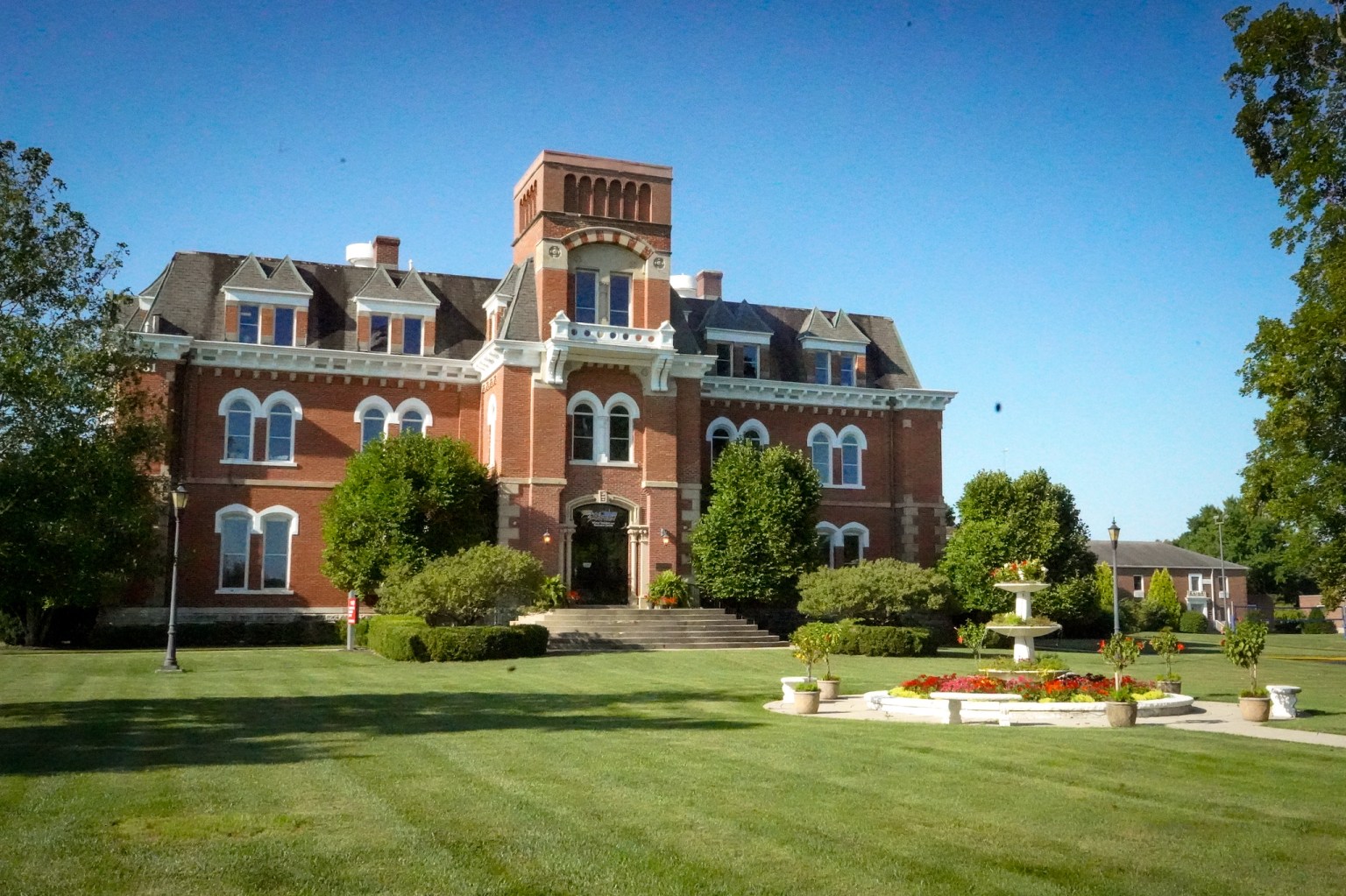 Historic red brick building with a bell tower at AIA headquarters in Xenia, Ohio