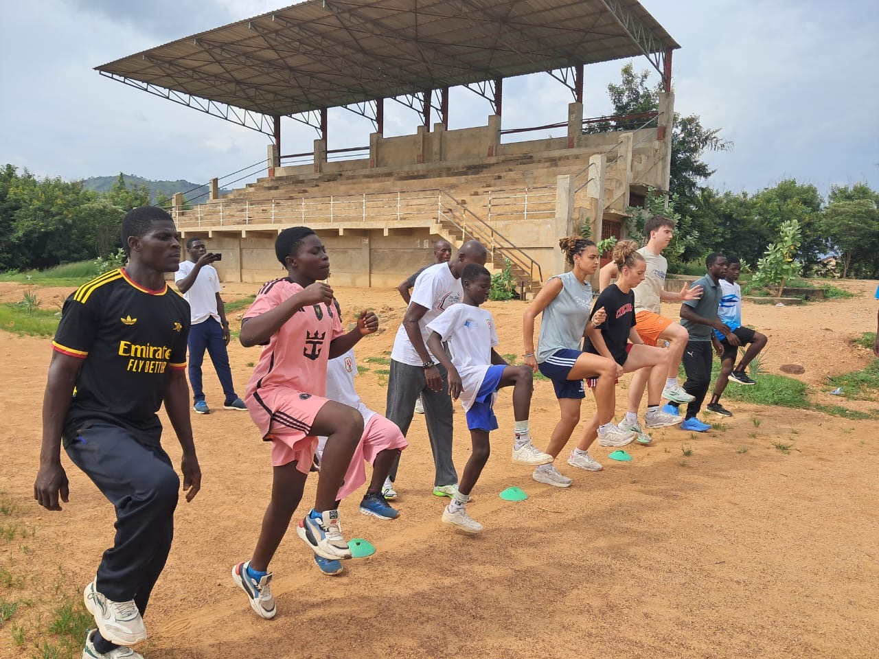 AIA track athletes leading running drills with local kids in Togo