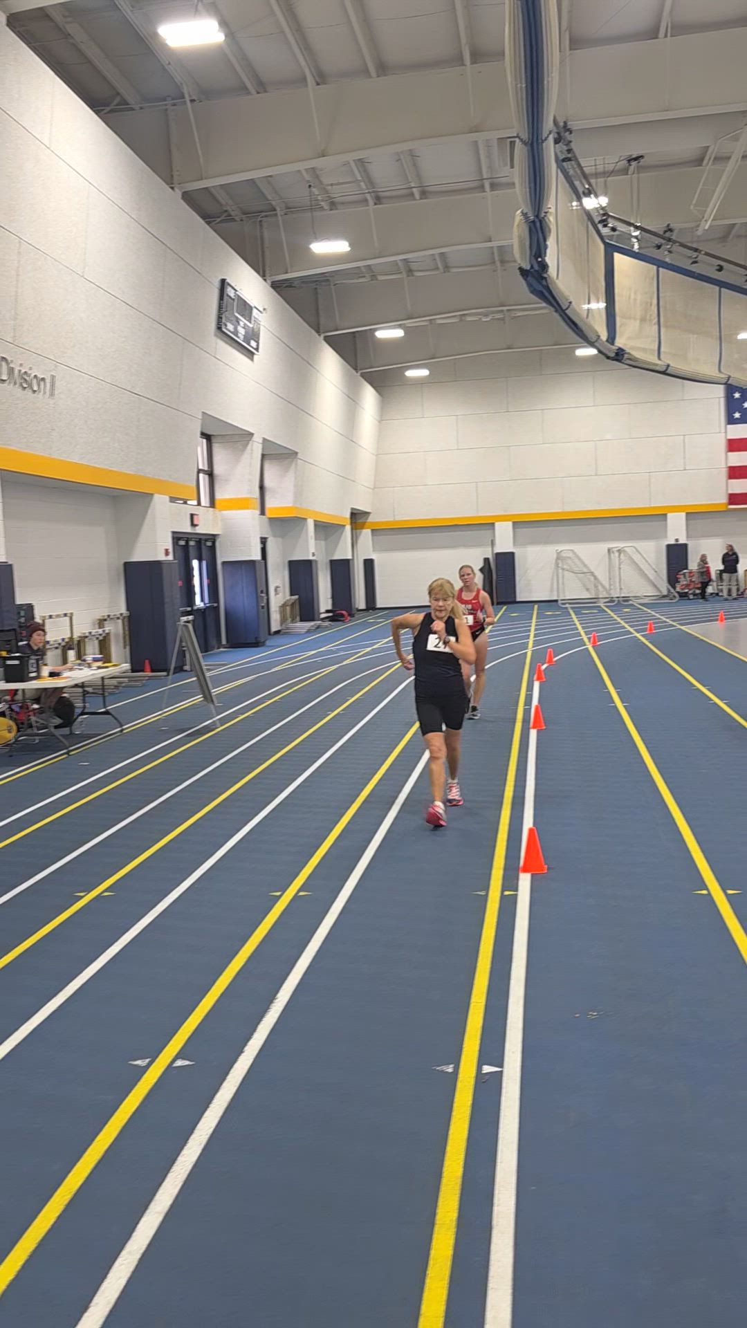 A runner training on an indoor track at an AIA camp