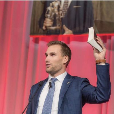 Kirk Cousins holding his Bible and giving his testimony
