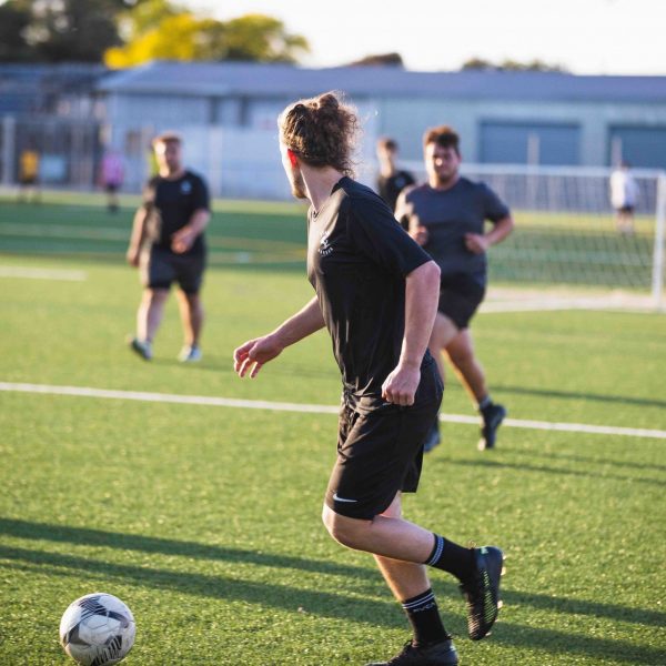 male athletes playing soccer outside