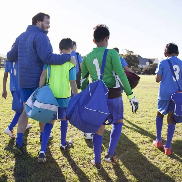 Boys soccer team, aged 12-14, leaving after a game with their coach